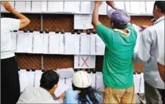  ?? PHA LINA ?? People search for their names on the NEC’s new voter lists in Phnom Penh’s Tonle Bassac commune in January this year.