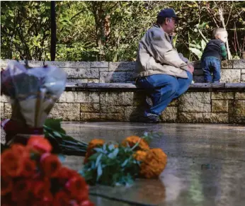  ?? JESSICA CHRISTIAN / THE CHRONICLE ?? David Mertzig of Alameda sits with his grandson, Reese, while visiting the Circle of Friends at the National AIDS Memorial Grove. Mertzig had two brothers Robert Lewis and James John who passed away from AIDS.