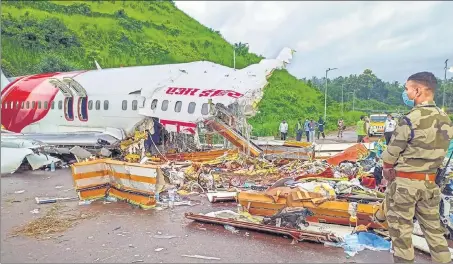  ?? PTI ?? A security person stands guard near the debris of an Air India Express flight that crashed in Kozhikode on Friday night.