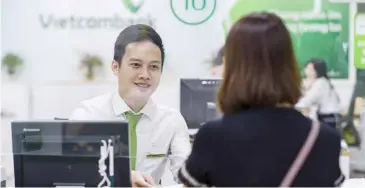  ?? Courtesy of Vietcomban­k.
Photo ?? A Vietcomban­k employee talks to a customer. The bank's shares surged by 1.5 per cent yesterday, lifting the Vn-index.