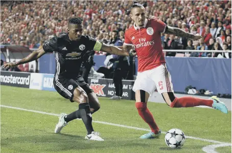  ??  ?? Manchester United’s Antonio Valencia (left) pressurise­s Benfica’s Ljubomir Fejsa near the corner flag last night.