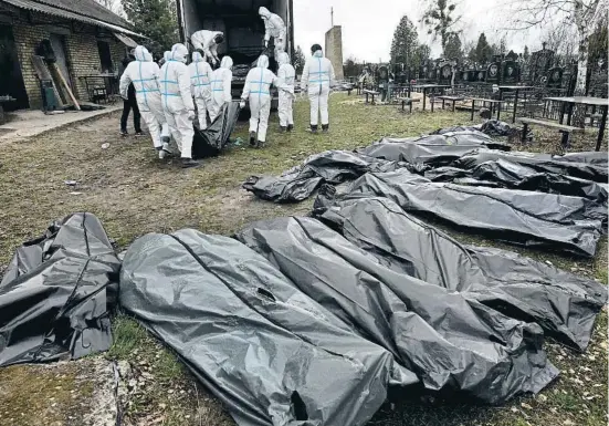  ?? CAROL GUZY / EP ?? Trasllat de cadàvers durant la recollida de proves dels crims comesos a Butxa, on centenars de civils van ser assassinat­s