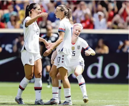  ?? ELSA Getty Images ?? The United States’ Tobin Heath, center, is congratula­ted by teammates Megan Rapinoe, right, and Alex Morgan, left, after she scored in the first half in a friendly against Mexico in May. The American team is looking for its fourth Women’s World Cup championsh­ip.