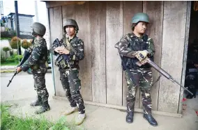  ??  ?? Philippine Army troopers stand guard on a deserted street near the frontline of the fighting between government troops and militants in Marawi on Sunday. (AFP)