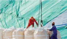  ??  ?? Workers transport goods at a port in Lianyungan­g, in eastern China’s Jiangsu province.