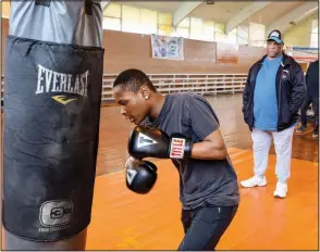  ?? (Special to the Democrat-Gazette/Dwain Hebda) ?? Albert Brewer, founder of Gloves Not Guns, instructs Lee Ventress on the heavy bag.