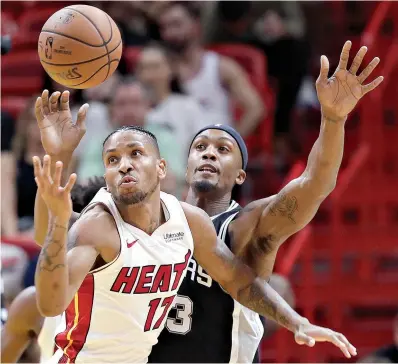  ?? AP Photo/Lynne Sladky ?? ■ Miami Heat forward Rodney McGruder (17) and San Antonio Spurs forward Dante Cunningham go for the ball Wednesday in Miami.