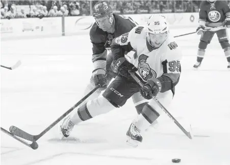  ?? MARY ALTAFFER, THE ASSOCIATED PRESS ?? Senators centre Matt Duchene tries to fend off a check from Islanders winger Jason Chimera on Friday.