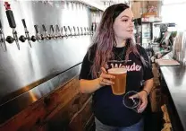  ?? Melissa Phillip / Staff photograph­er ?? Allyson Boyd, a taproom manager, serves beer at 8th Wonder Brewery and Distillery, which has yet to return to pre-COVID staffing levels. The industry saw widespread layoffs once the pandemic emerged.