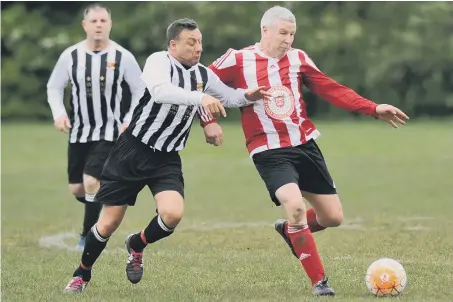  ??  ?? John Hogg Funerals (red and white shirts) battle against Blakelaw SC in the Over-40s League last week. Picture by Tim Richardson