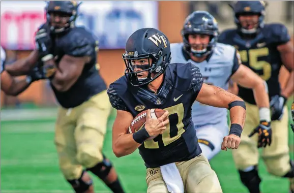  ?? [NELL REDMOND/THE ASSOCIATED PRESS] ?? Wake Forest quarterbac­k Sam Hartman carries the ball against Towson in the second half Sept. 8 in Winston-Salem, N.C.