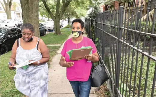  ?? MARK BROWN/SUN-TIMES ?? Communitie­s United organizers Electa Bey (left) and Hiwotenshe Bekele go door-to-door Thursday in Belmont Cragin to inform tenants and landlords about programs designed to help with pandemic-related financial problems.