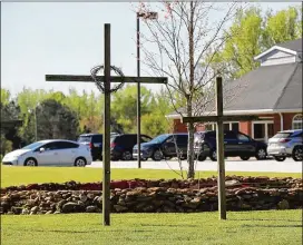  ??  ?? Despite most church parking lots across Georgia and the country being starkly empty in the past month, the Union Springs Baptist Church parking lot is dotted with cars during the week, with kids finsihing homework — and practicing social distancing.