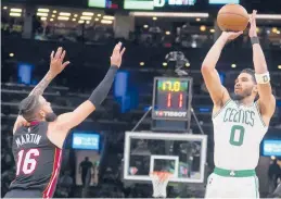  ?? CHARLES KRUPA/AP ?? Jayson Tatum shoots over Heat forward Caleb Martin during the Celtics’ 102-82 victory in Game 4 of the Eastern Conference finals Monday. Tatum had 31 points.