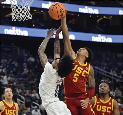  ?? DAVID BECKER — GETTY IMAGES ?? USC’s Boogie Ellis blocks an inside shot by Washington’s Koren Johnson during Wednesday’s first-round game in the Pac-12Tourname­nt.