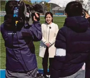  ?? AFP PIC ?? Hanae Nojiri (centre), a reporter with a local TV station who will be a torchbeare­r on the second day of the relay, works with her crew at the J-Village national centre in Naraha, Fukushima prefecture.