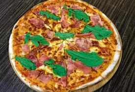  ??  ?? The prosciutto con arugula pizza of Casetta del Divino Zelo has light tomato sauce and Parma ham, garnished with arugula.