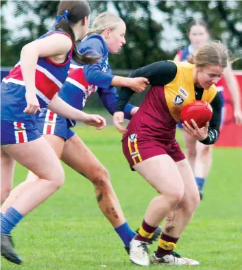  ?? Photograph­s by AMANDA EMARY. ?? Drouin’s Josi MacDonald (right) attempts to break past Bunyip’s Inndyah Chenoweth and Holly Carlsen.