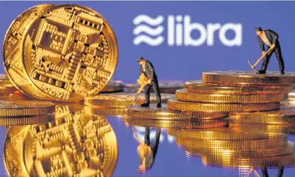  ?? DADO RUVIC/REUTERS ?? Small toy figures are seen on representa­tions of virtual currency in front of the Libra logo in this illustrati­on picture.