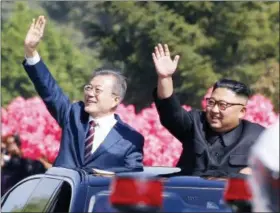  ?? PYONGYANG PRESS CORPS POOL VIA AP ?? South Korean President Moon Jae-in, left, and North Korean leader Kim Jong-un wave from a car during a parade through a street in Pyongyang, North Korea, Tuesday.