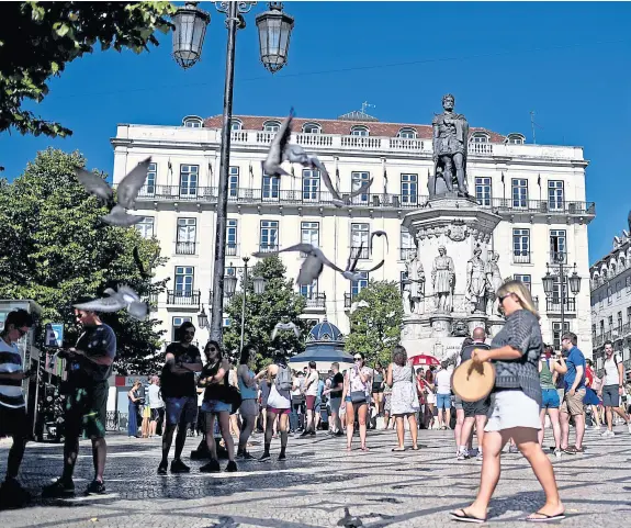  ??  ?? Miles de turistas llegan a diario a Lisboa y pasean por la Plaza Camoes