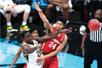  ?? AP Photo/Michael Conroy ?? ■ Baylor forward Jonathan Tchamwa Tchatchoua (23) passes around Houston guard Quentin Grimes (24) during the second half of a Final Four NCAA basketball tournament semifinal game Saturday at Lucas Oil Stadium in Indianapol­is.