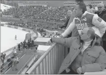  ?? Associated Press photo ?? In this 2014 file photo, Russian President Vladimir Putin, foreground, watches downhill ski competitio­n of the 2014 Winter Paralympic­s in Roza Khutor mountain district of Sochi, Russia, as Russia's sports minister Vitaly Mutko stands behind. On...