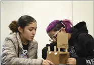  ??  ?? Reading High senior Jazlynn Marie Montalvo, left, and junior Shyann Ilei Eaddy work on their earthquake-proof structure during the Project in a Box portion of the Berks County Intermedia­te Unit Governor’s STEM Competitio­n on Thursday.