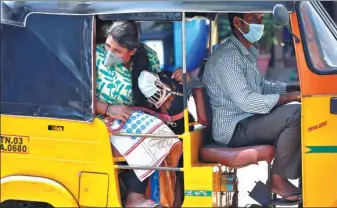  ?? P. RAVIKUMAR / REUTERS ?? A dog wearing a protective mask sits with its owner inside an auto-rickshaw in Chennai, India, on Monday as a 21-day nationwide lockdown continues in the country.