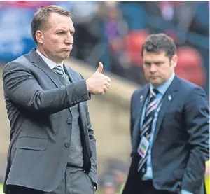  ?? Picture: SNS. ?? A photo that tells a story – a happy Brendan Rodgers and a pretty disconsola­te-looking Graeme Murty.