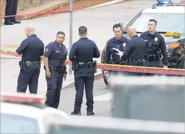 ?? Gary Coronado Los Angeles Times ?? LAPD OFFICERS at the site where Freddy Bailon was shot by an officer outside a building at USC’s medical campus in Boyle Heights. Bailon was charged with 10 felony counts, including committing lewd acts on a child.