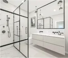  ??  ?? The bathrooms have heated tile flooring, floating vanities with plenty of mirror space, modern frame shower stalls and distinctiv­e pendant lighting.