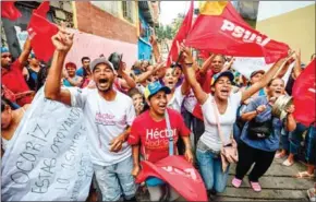  ?? JUAN BARRETO/AFP ?? Supporters of Venezuelan President Nicolás Maduro shout slogans against at a polling station to vote during regional elections, in Caracas, on Sunday.