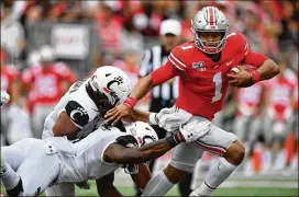  ?? JAMIE SABAU / GETTY IMAGES ?? Ohio State QB Justin Fields (1), who transferre­d from Georgia, had four total TDs Saturday against Cincinnati as the host Buckeyes won 42-0.