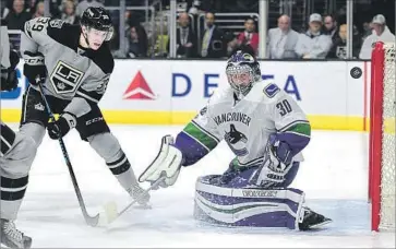  ?? Harry How Getty Images ?? VANCOUVER GOALIE Ryan Miller keeps his eye on the puck after a deflected shot by the Kings’ Adrian Kempe in the second period. Kempe would get two assists, but it wasn’t enough for the Kings.