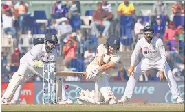  ??  ?? A puff of dust explodes on the pitch as Rory Burns tries to sweep one from Axar Patel on Monday.