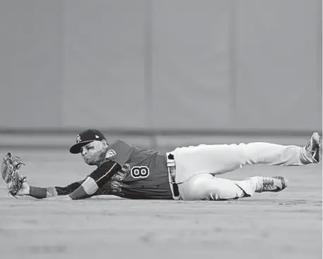 ?? Harry How, Getty Images ?? Rockies right fielder Gerardo Parra slides after making a catch to get Los Angeles Dodgers right fielder Matt Kemp out during the fourth inning Tuesday night at Dodger Stadium. Parra later moved to left field.