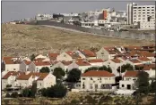  ?? MAYA ALLERUZZO — THE ASSOCIATED PRESS ?? The east Jerusalem Israeli settlement of Pisgat Ze'ev, seen next to a section of the controvers­ial separation barrier, on Thursday.