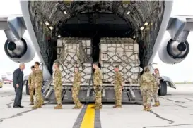  ?? AP PHOTO/MICHAEL CONROY ?? Agricultur­e Secretary Tom Vilsack, left, greets crew members of a C-17 delivering a load of baby formula at the Indianapol­is Internatio­nal Airport in Indianapol­is on Sunday.