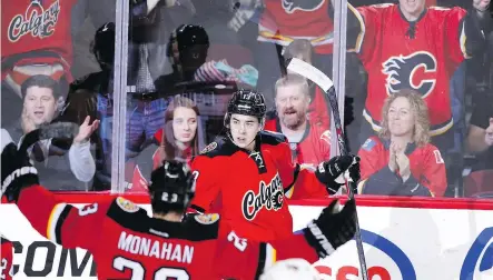  ?? LARRY MACDOUGAL/ THE CANADIAN PRESS ?? Flames forward Johnny Gaudreau, centre, celebrates with Sean Monahan after scoring against the Arizona Coyotes during the first period Tuesday night in Calgary.