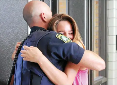  ?? KRISTI GARABRANDT — THE NEWS-HERALD ?? Mike Shaw, school resource officer at Chardon High School gets a hug from former student Laina Barajas, who said his presence in the school made her feel better.