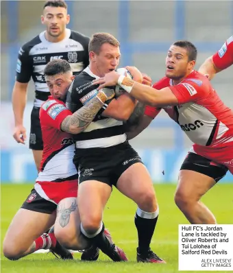  ?? ALEX LIVESEY/ GETTY IMAGES ?? Hull FC’S Jordan Lane is tackled by Oliver Roberts and Tui Lolohea of Salford Red Devils