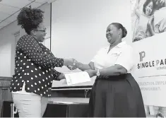  ?? Staff photo by Hunt Mercier ?? ■ Brandy Davis from Little River County, Ark., accepts the Single Parent Scholarshi­p award Monday from Arkansas Single Parent Scholarshi­p Fund Region 6 Program Manager Sandra Warren at Texarkana College. The purpose of the scholarshi­p is to support single parents and help them through a traditiona­l or technical school program. Twenty-two people from Little River, Miller and Bowie counties received the award.