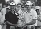  ?? Louisiana. GERALD HERBERT/AP ?? Xander Schauffele, left, and teammate Patrick Cantlay hold up the trophy Sunday after winning the PGA Zurich Classic golf tournament at TPC