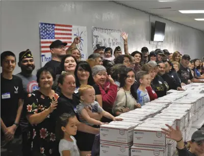  ?? PHOTO TOM BODUS ?? Volunteers gather behind the 150 care packages they boxed up Sunday morning at the American Legion Boyce Aten Post 25. The packages will be shipped to Qatar, to members of California National Guard Alpha Company 578 BEB, out of El Centro.