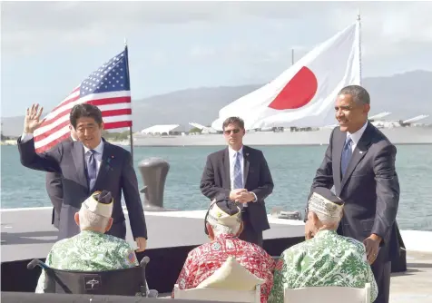  ?? — Reuters ?? US President Barack Obama (R) looks on as Japanese Prime Minister Shinzo Abe greets veterans at Kilo Pier overlookin­g the USS Arizona Memorial on Tuesday at Pearl Harbor in Honolulu, Hawaii. Abe and Obama made a joint pilgrimage to the site of the...