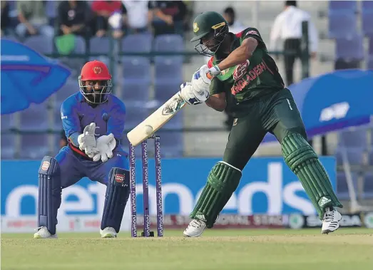  ?? AFP ?? Bangladesh batsman Mahmudulla­h plays a shot during his side’s narrow three-run victory over Afghanista­n at the Zayed Cricket Stadium in Abu Dhabi on Sunday