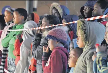  ??  ?? Township talent: Xolile Madinda, founder of the Fingo Festival, and some spellbound young patrons watching a performanc­e. The festival has been running for seven years, bringing audiences into Makhanda’s townships and helping to narrow the gap between...