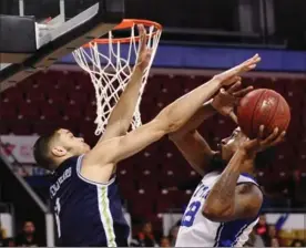  ?? IAN STEWART, SPECIAL TO THE RECORD ?? Titans’ Kevin Rogers is blocked by Guillaume Payen Boucard in a 103-96 loss to the Lions.