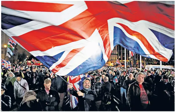  ??  ?? Brexit supporters celebrate in Parliament Square as the long-awaited moment arrives